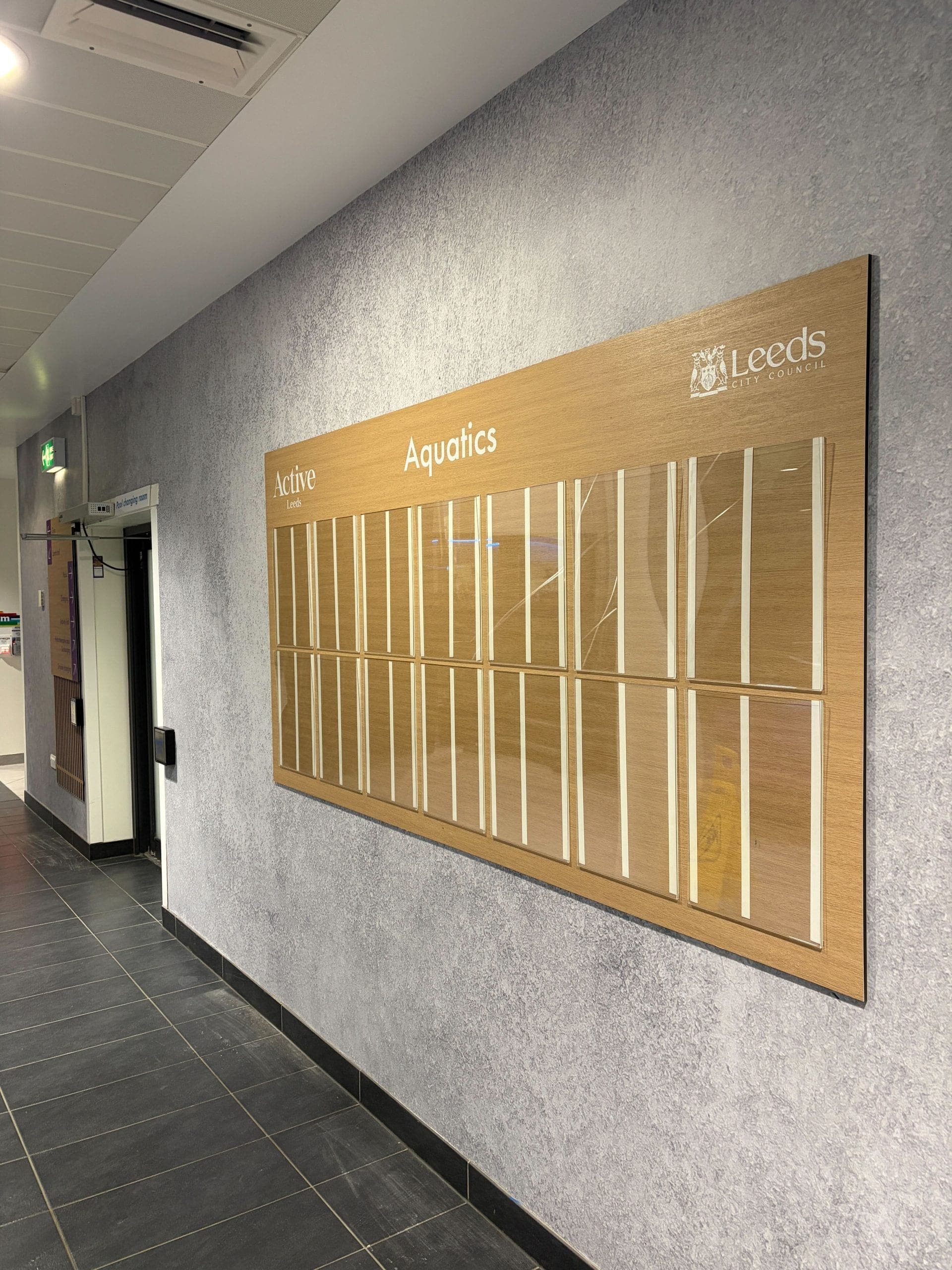 Active Leeds Aquatics timetable display board in oak finish with acrylic schedule inserts