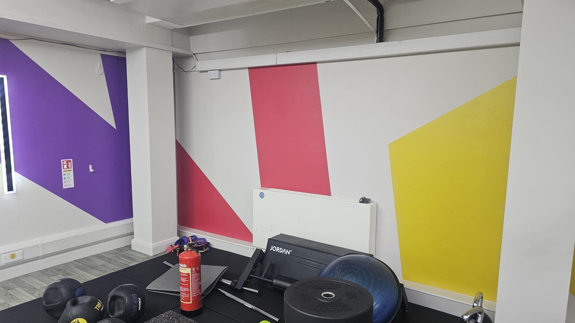 Studio room with red, yellow and purple geometric wall graphics