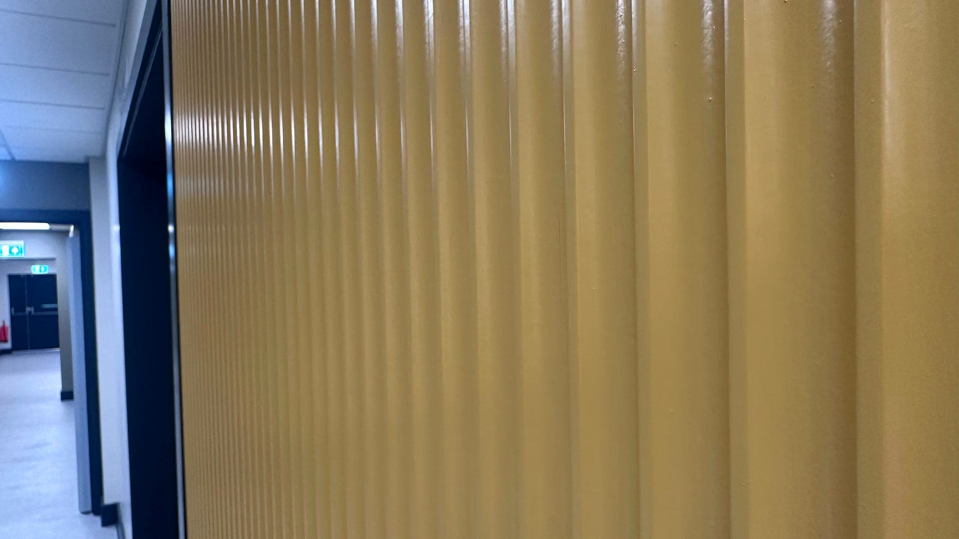 MyActive Leek fluted panelling — warm gold finish in corridor