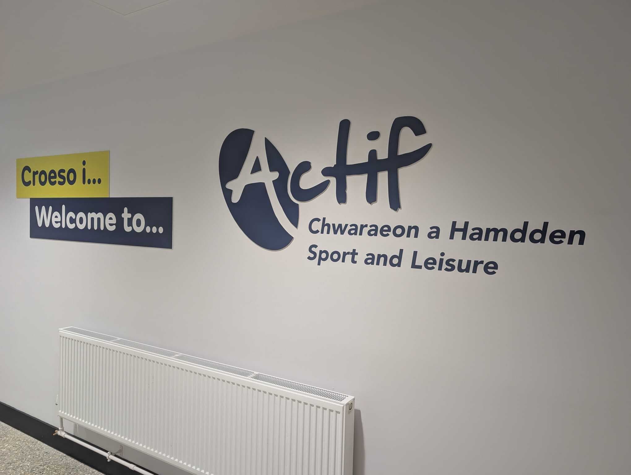 Welcome wall with large Actif Sport and Leisure dimensional logo and bilingual signage