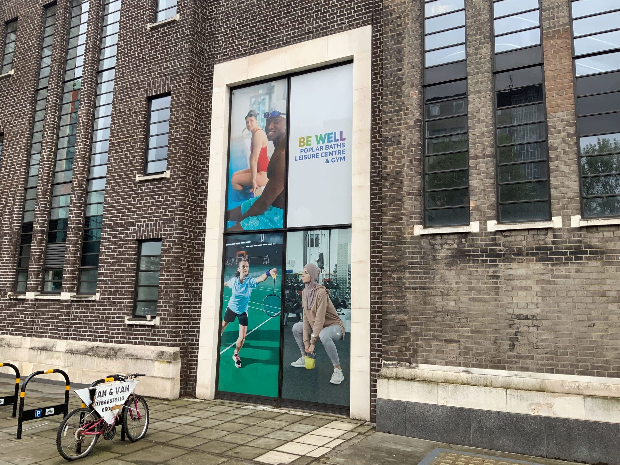 Poplar Baths exterior with window graphics showing swimmers and gym users