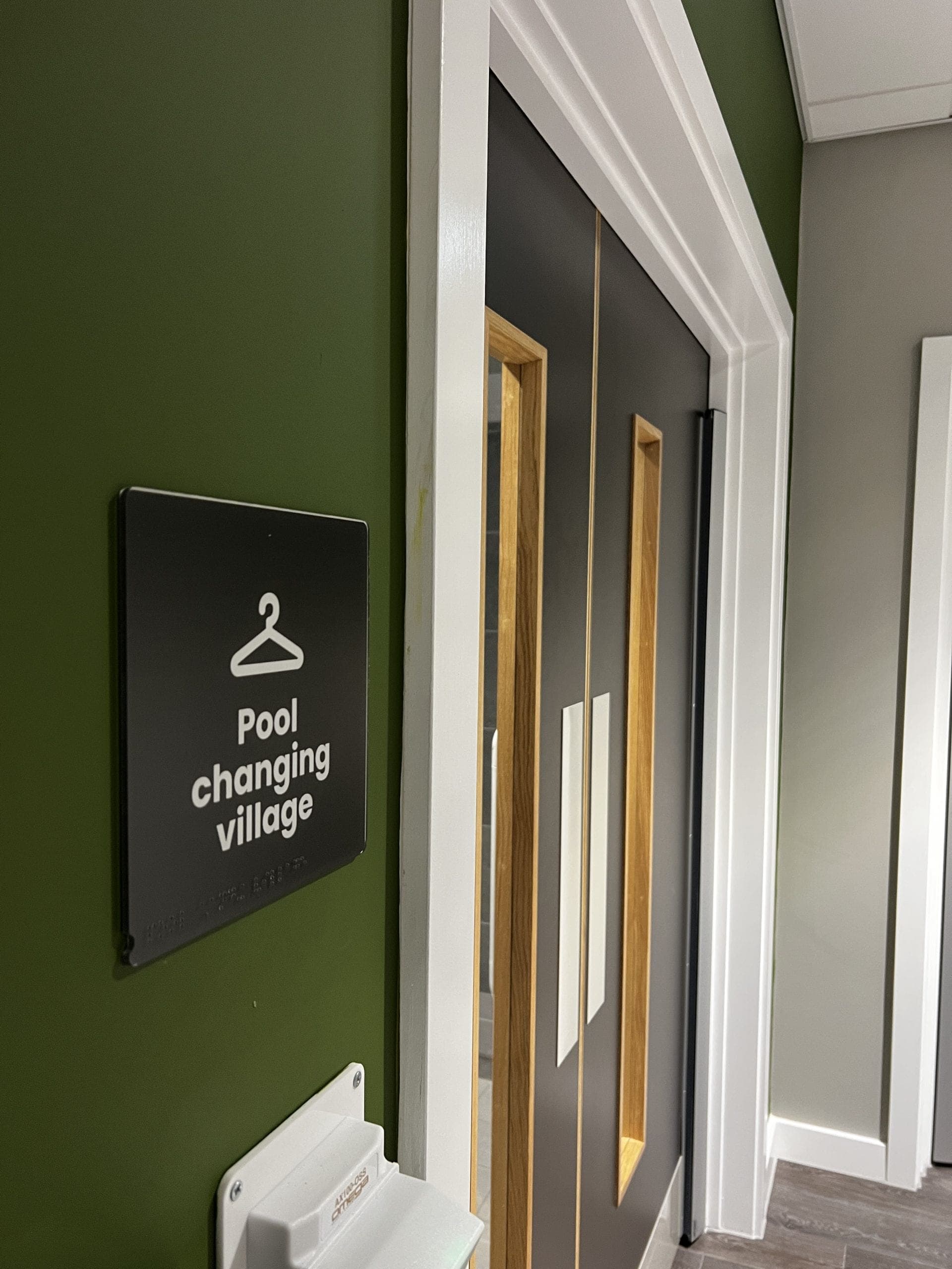 Pool changing village sign on green accent wall