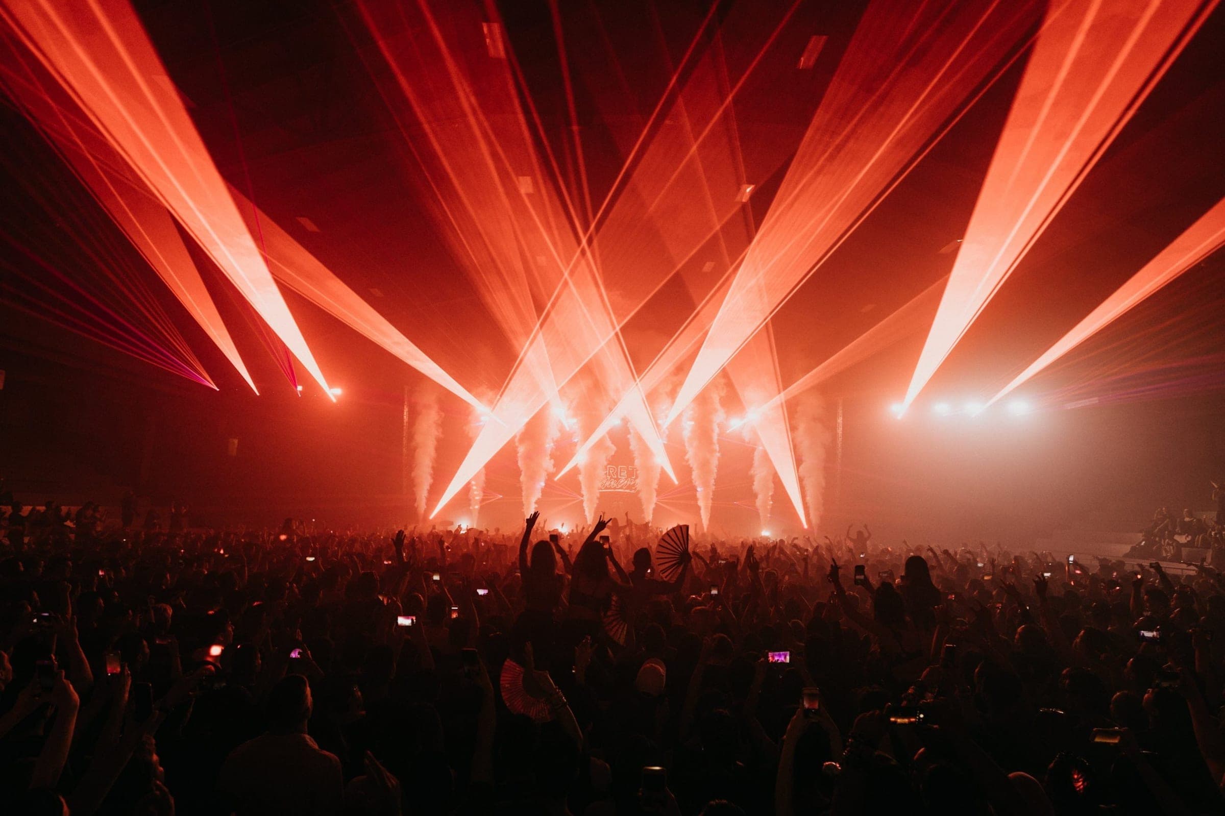 Concert crowd with dramatic red laser beams