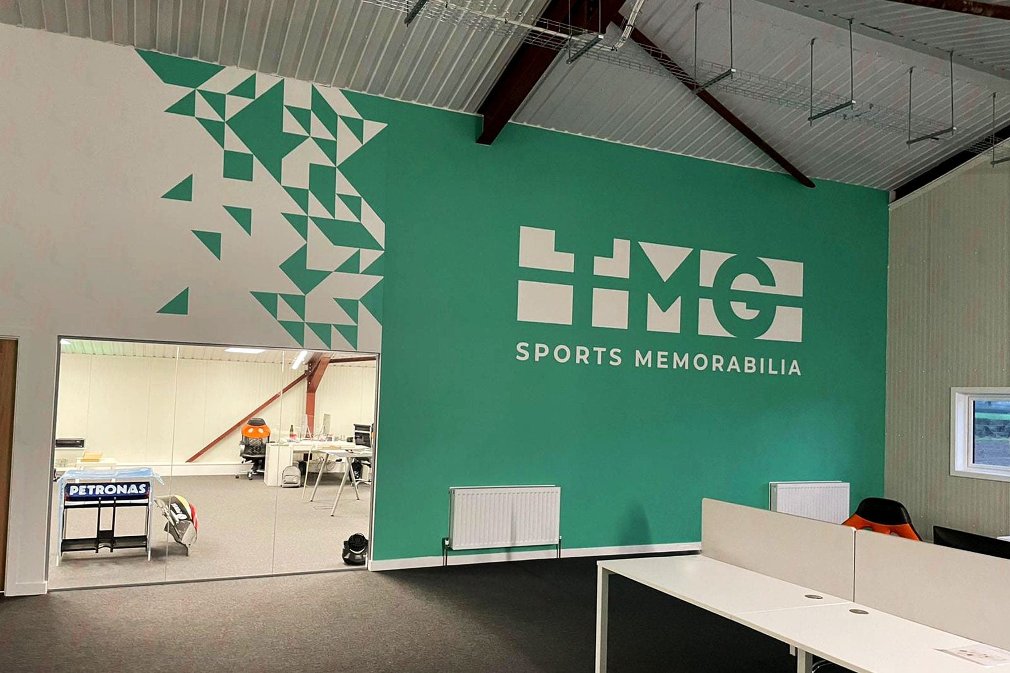 TMG Sports Memorabilia branded teal feature wall in The Memento Group HQ
