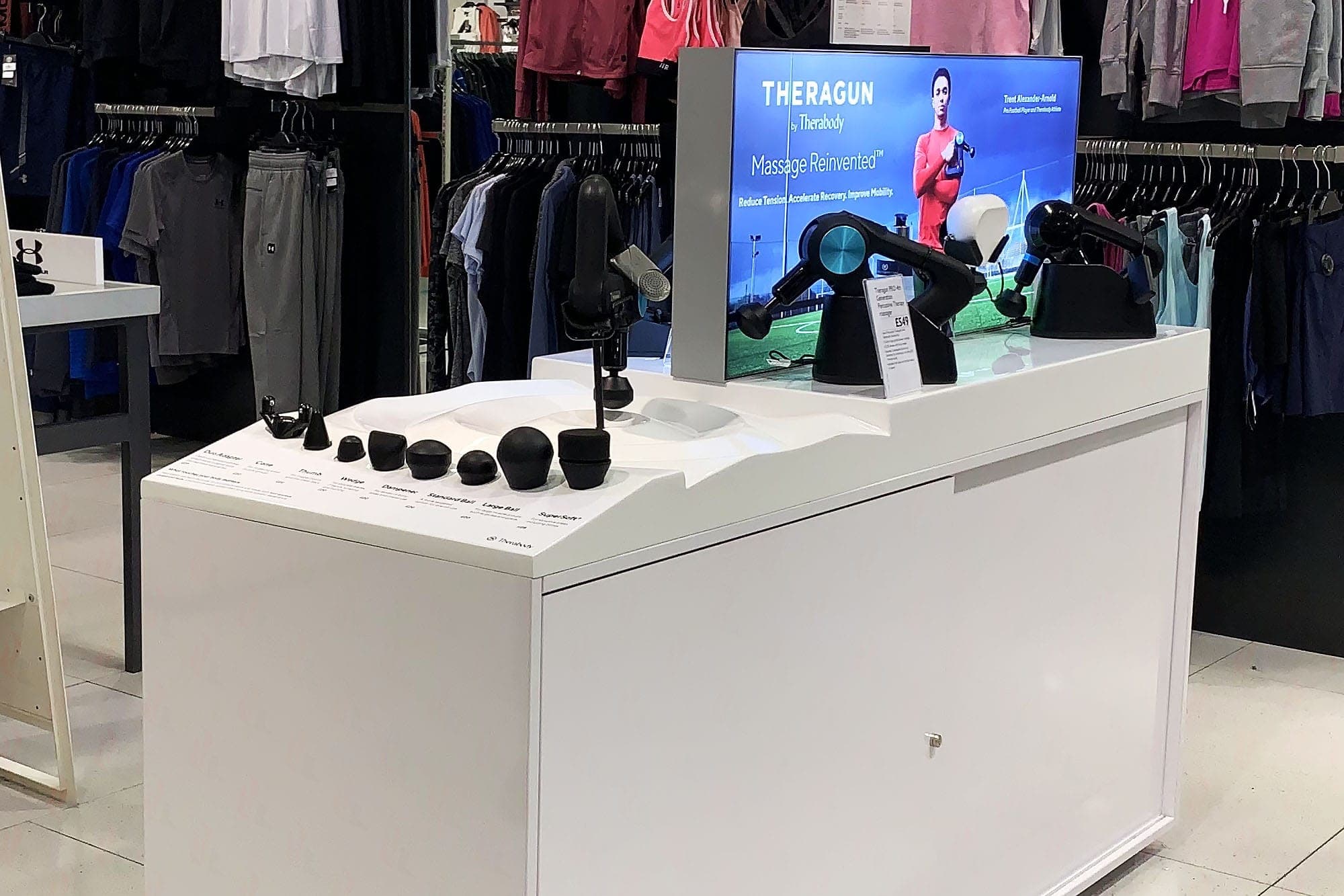 Theragun display unit with attachment heads and branded screen in John Lewis sportswear department
