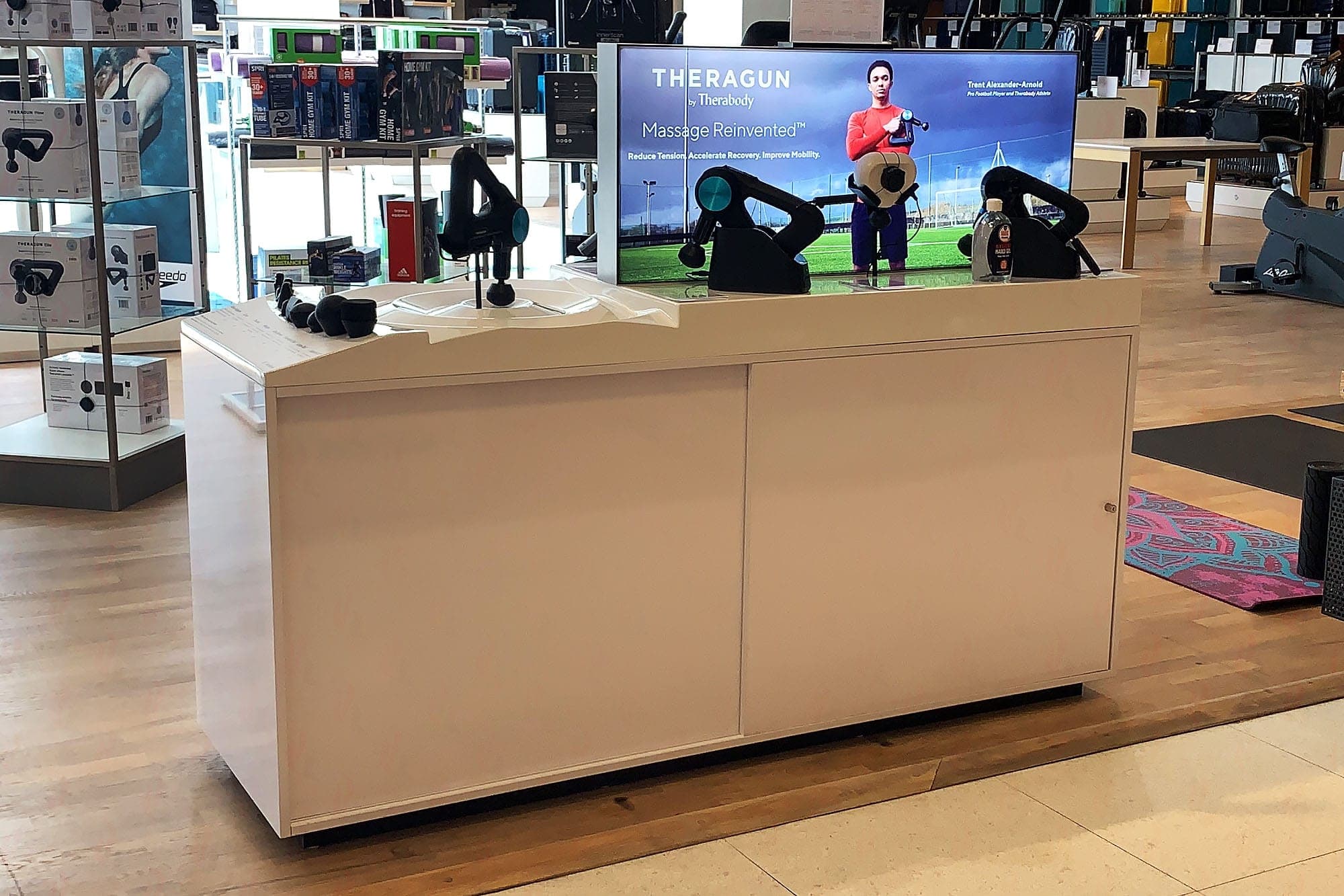 Therabody gondola display unit in John Lewis sports floor with branded screen and devices on show